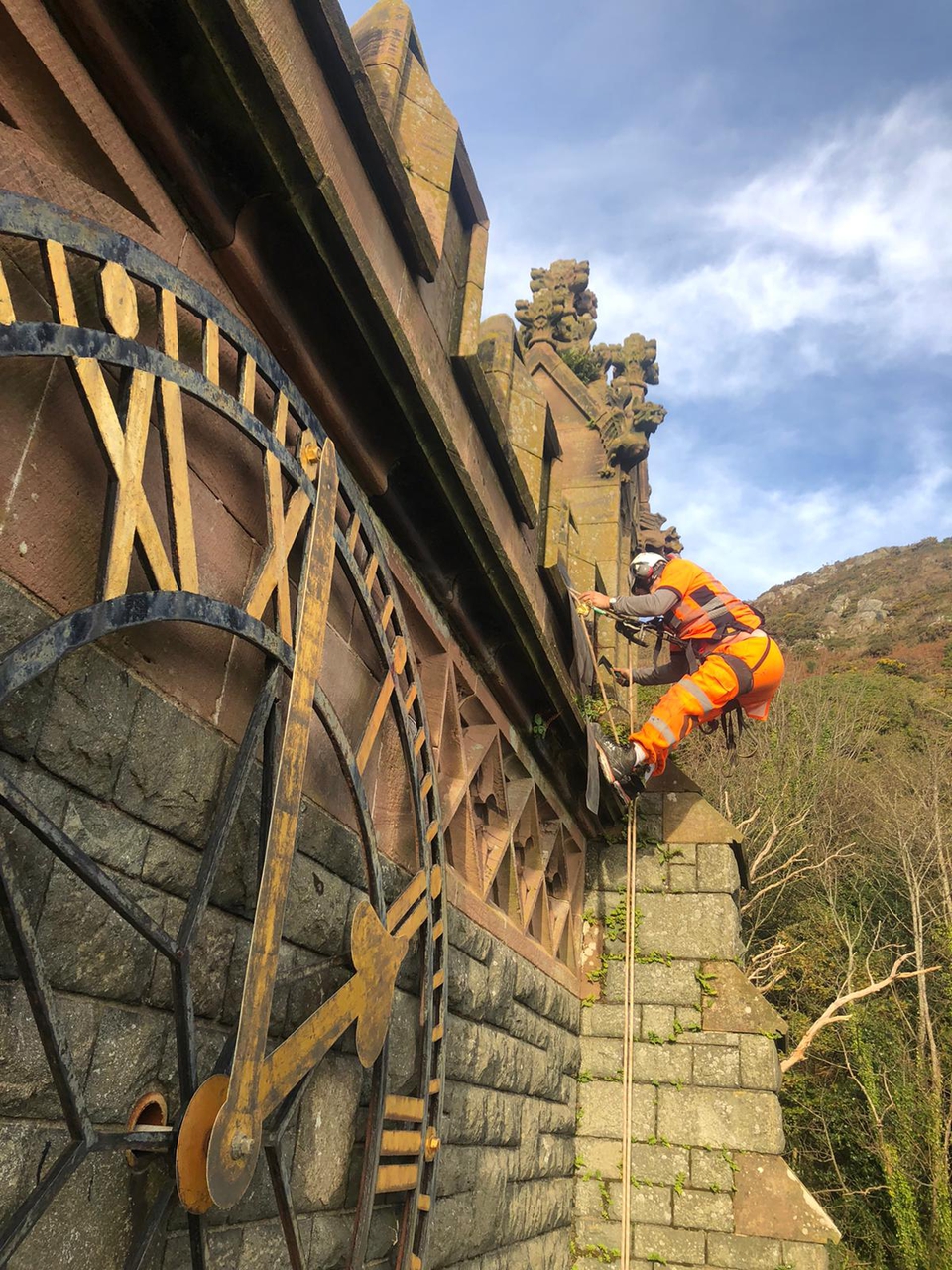 Abseiler undertaking maintenance of the tower at St John's Barmouth